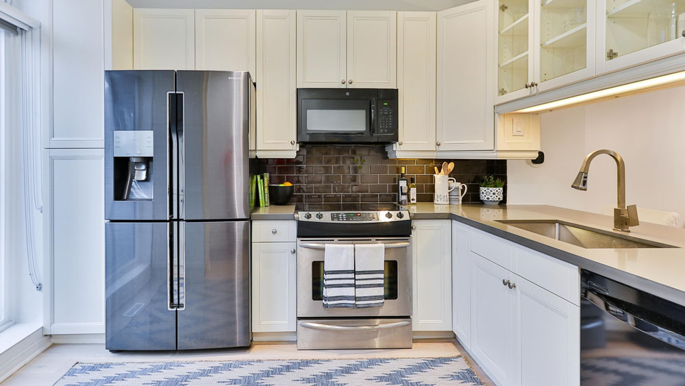A bright, modern kitchen with a stainless steel refrigerator & ice maker