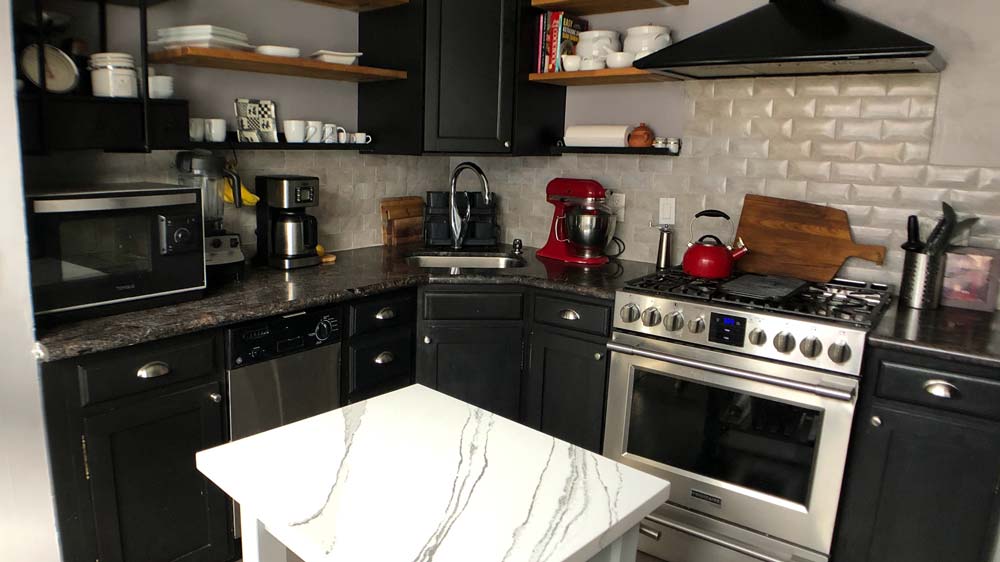 A kitchen with a stainless steel oven and vent hood