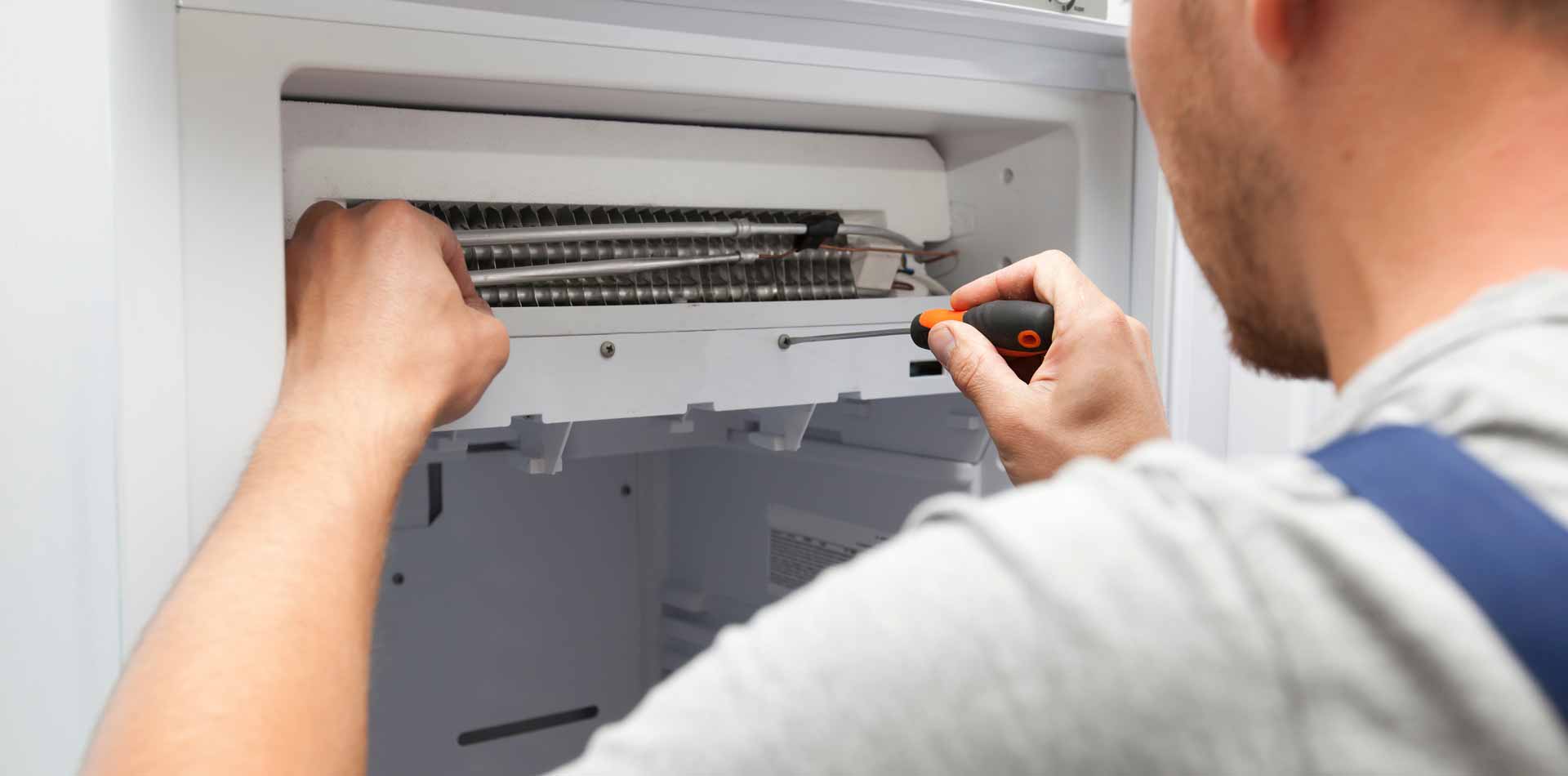 Appliance repair technician repairing a freezer