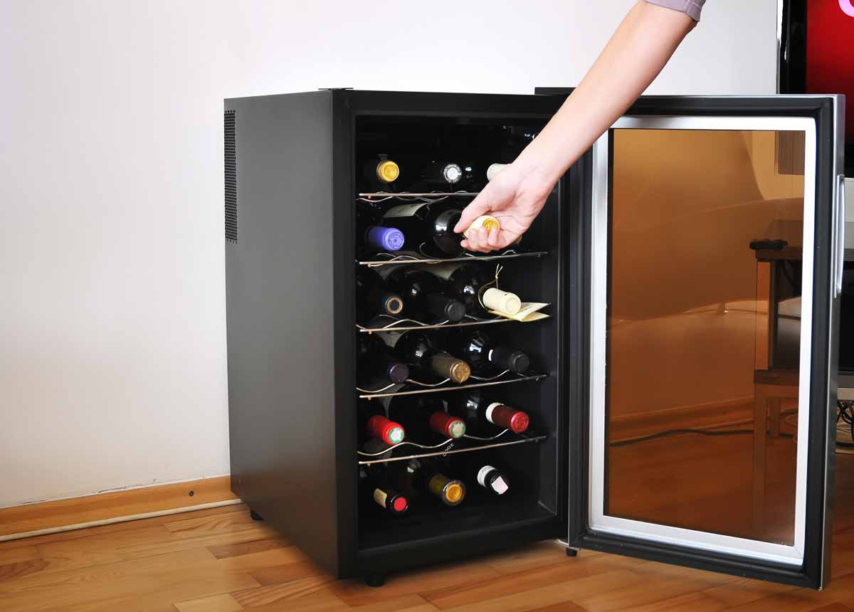 Woman's hand reaching in to wine cooler